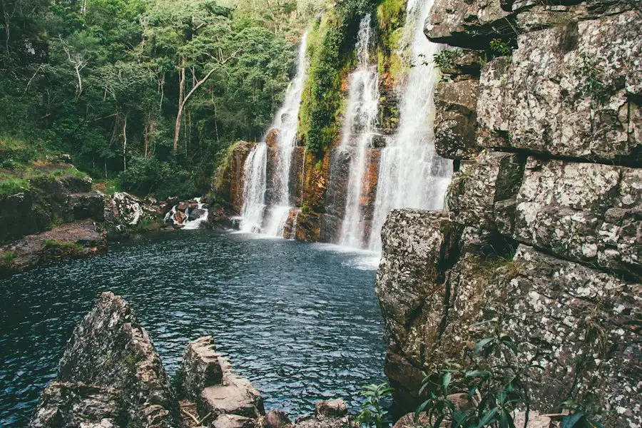 Cachoeira de águas claras entre paredões de pedra e mata, na Chapada dos Veadeiros