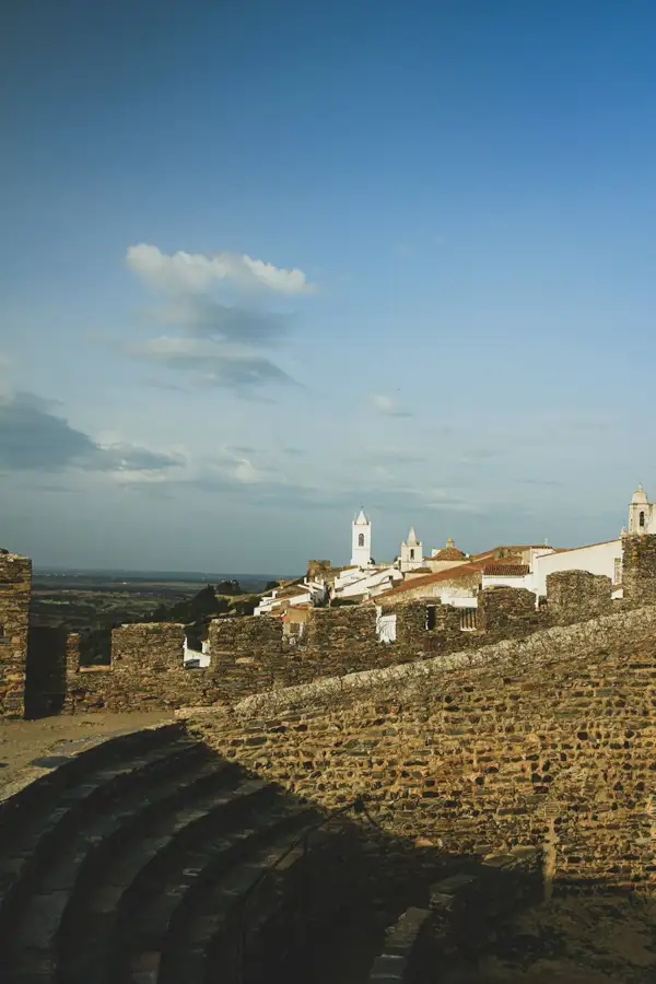 Muralhas de pedra e casas brancas de Monsaraz, no Alentejo, com o lago Alqueva ao fundo