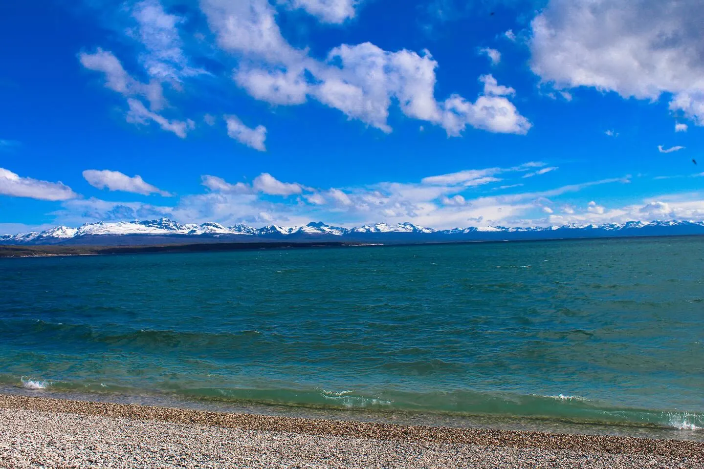 Lago Fagnano azul com a cordilheira nevada ao fundo